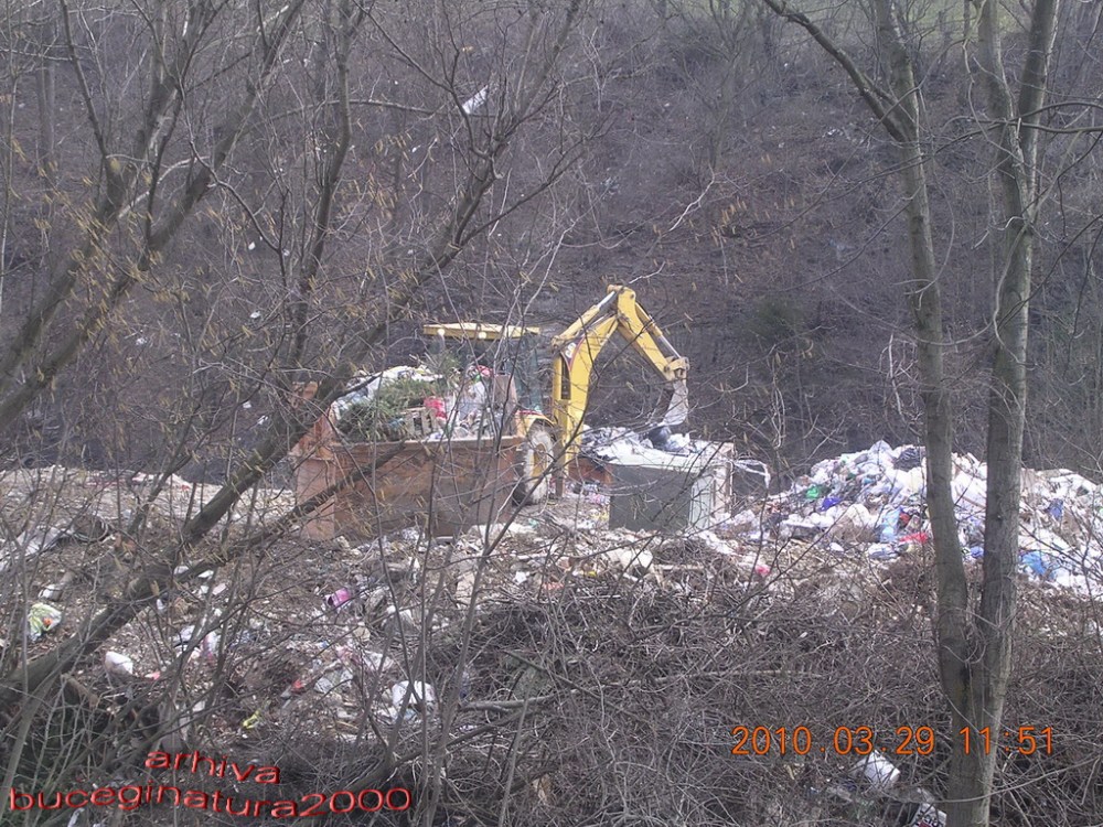 3.Excavator ce indeasa gunoaiele in containere, multe gunoaie cad in apa